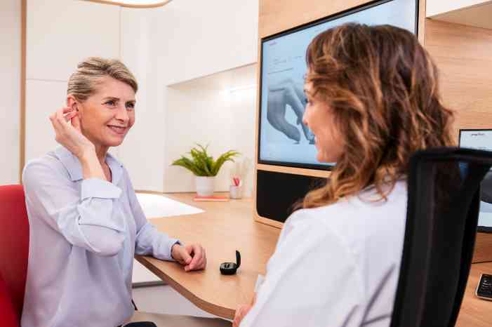 an audiologist examining the ear of a girl
