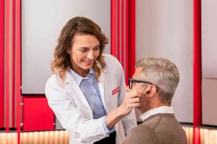 audiologist placing hearing aids