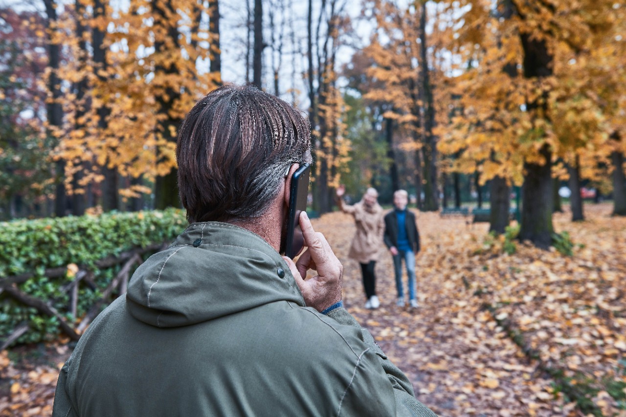 A man talks on the phone in the park