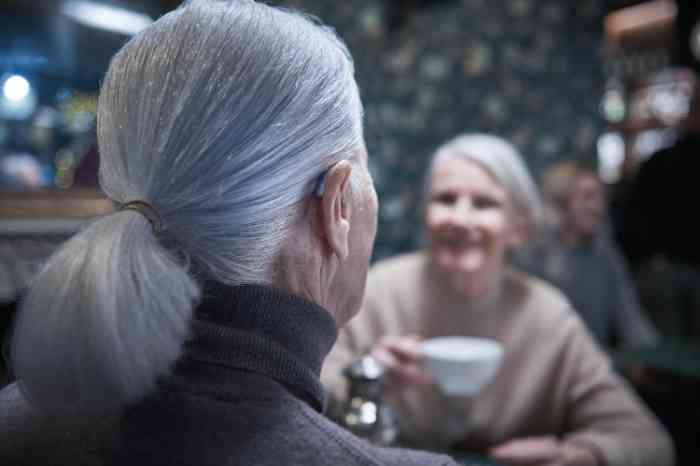 A woman wearing a hearing aid in a café	