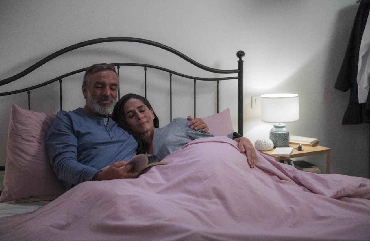 A couple reading a book in the bed 