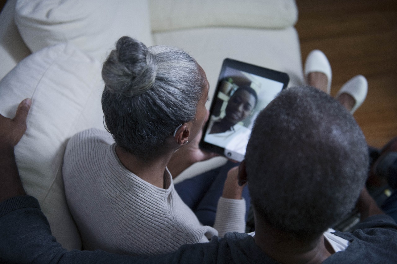 A couple making video call on a tablet with other people