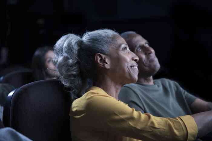 A woman wearing hearing aids enjoying a film at the cinema