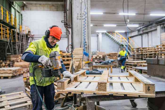 Worker using power tools with hearing protection in a noisy workshop