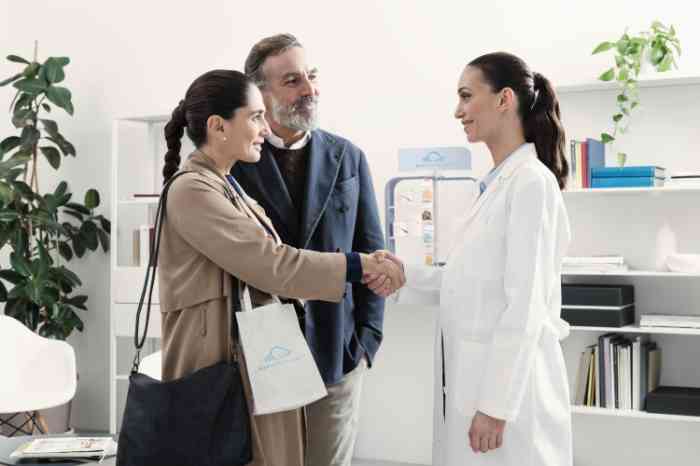 A hearing care professional receives two people at an appointment