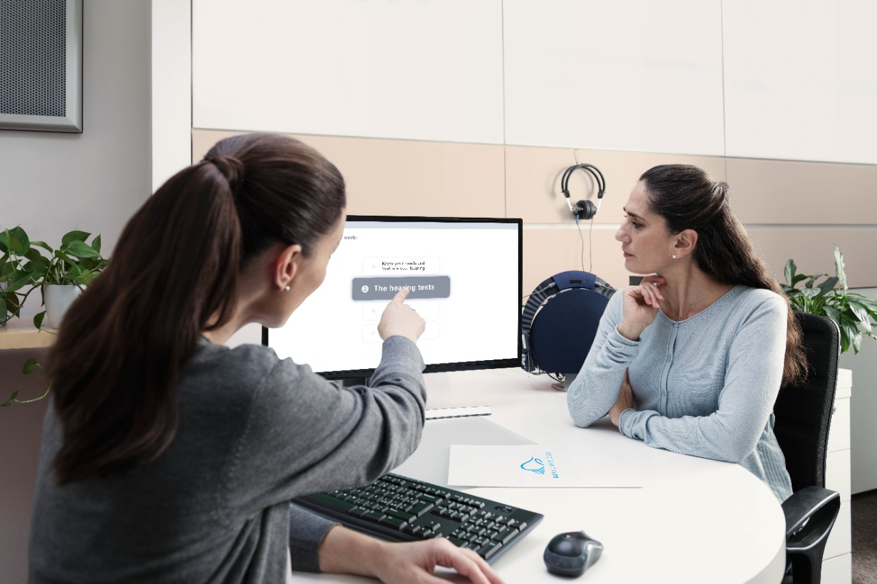 A woman taking an appointment with an hearing aid specialist