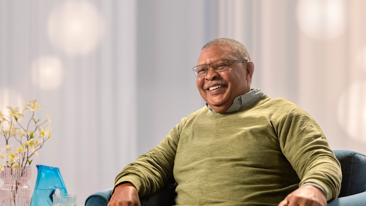 A man with glasses smiling