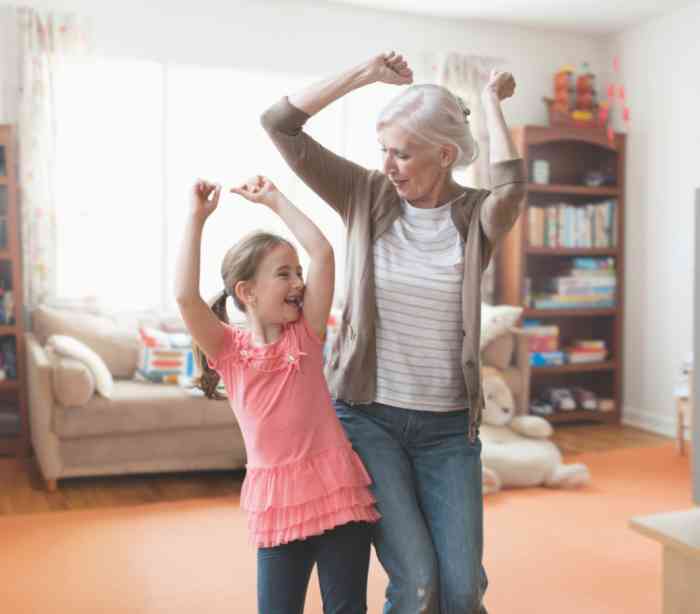 grandmother and little granddaughter smiling and dancing together