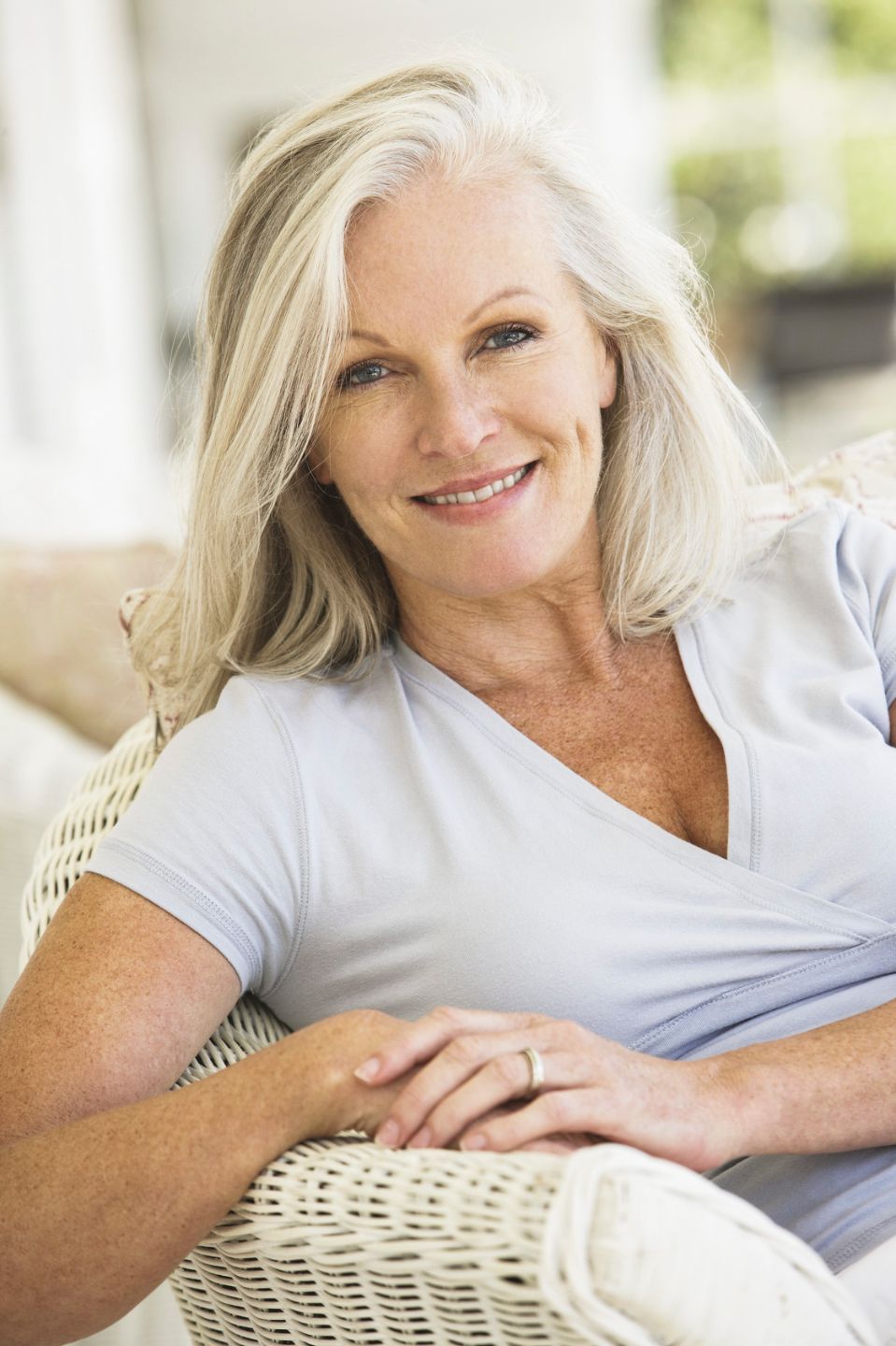 an elderly woman on her sofa smiling looking at the camera