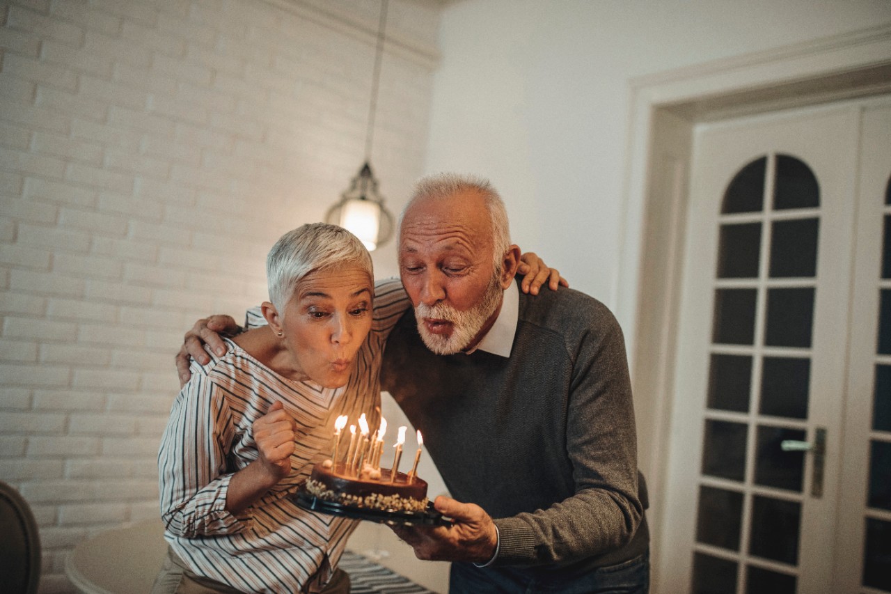 A couple blowing out the candles on the cake