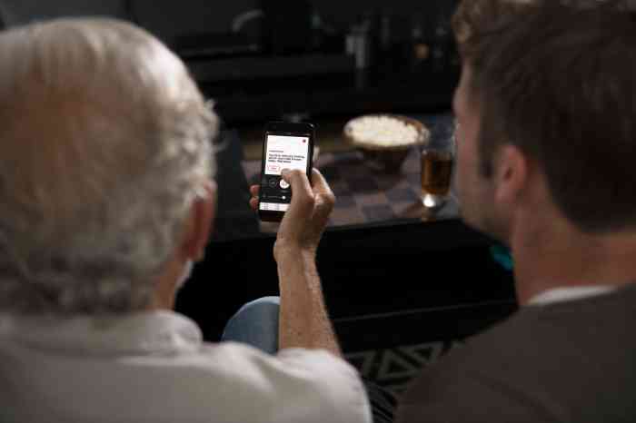 grandfather and grandson looking at Amplifon app on a smartphone