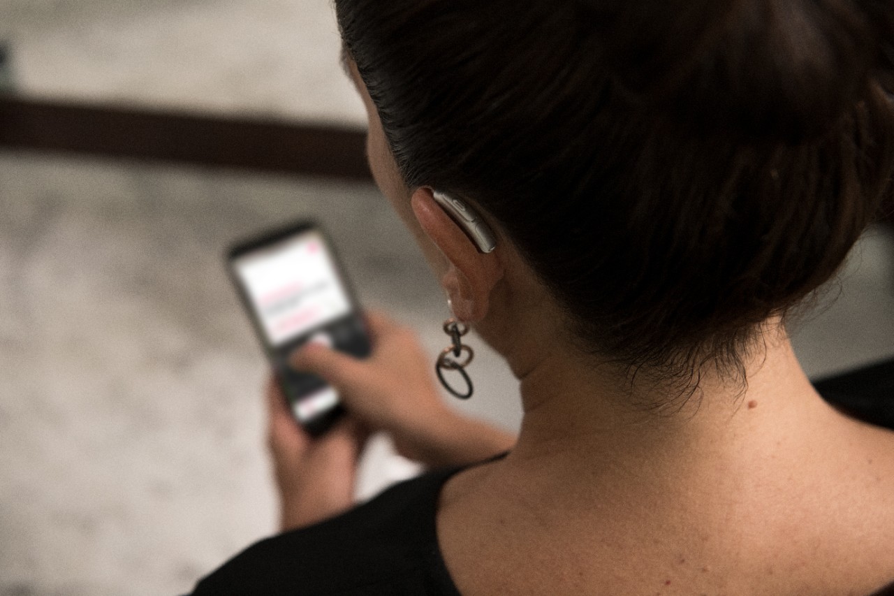 A woman from behind looking at her smartphone
