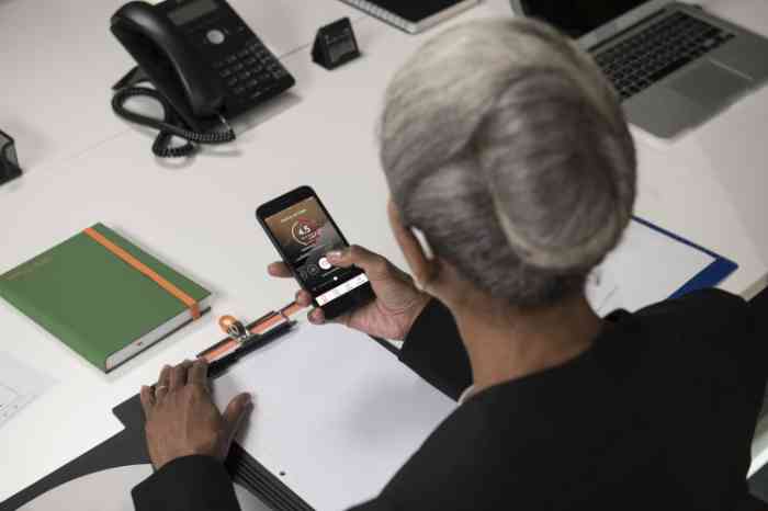 A woman is checking her hearing aid's app from her smartphone
