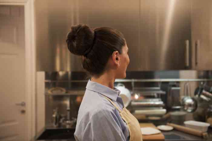 woman in a kitchen wearing a behind the ear hearing aid