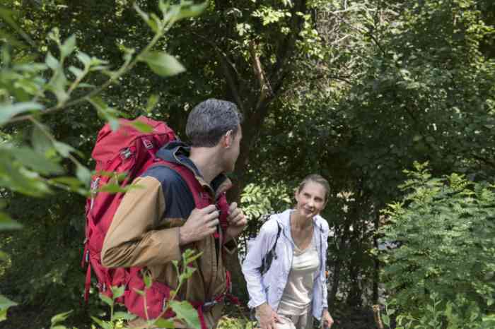 a man and a woman hiking in a wood