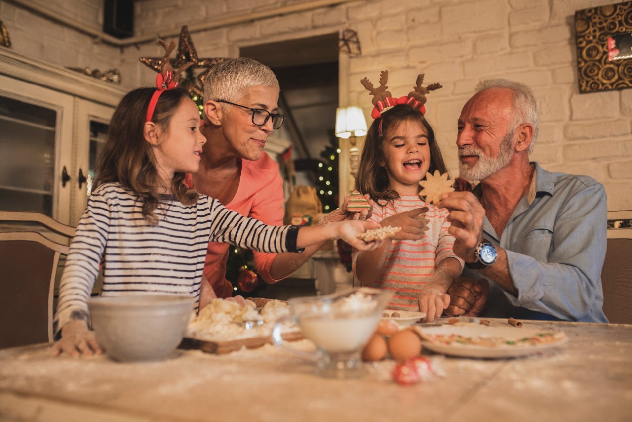 grandparents preparing Christmas cookies with their granddaughters