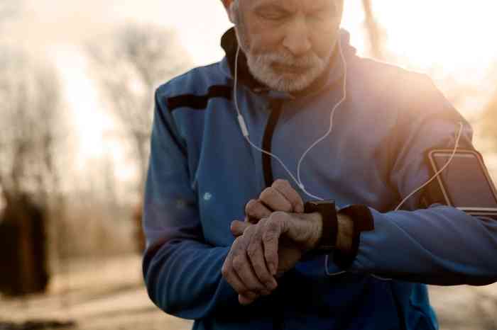 an elderly man checking his heartbeat after a run