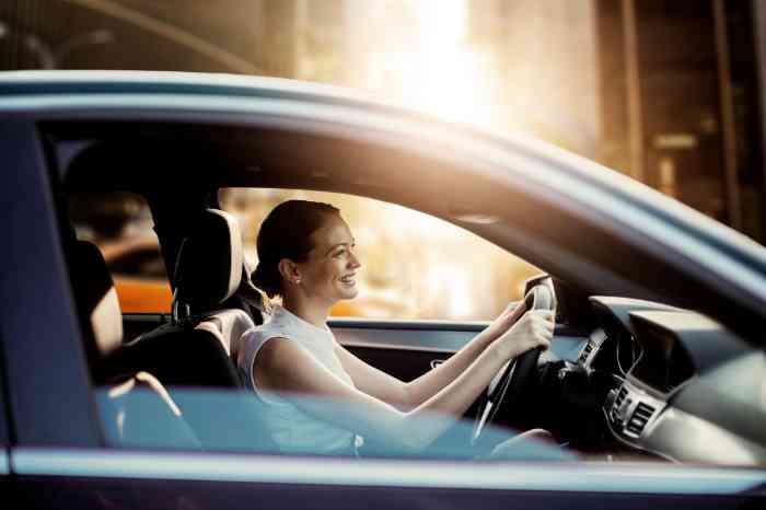a girl smiling while driving her car