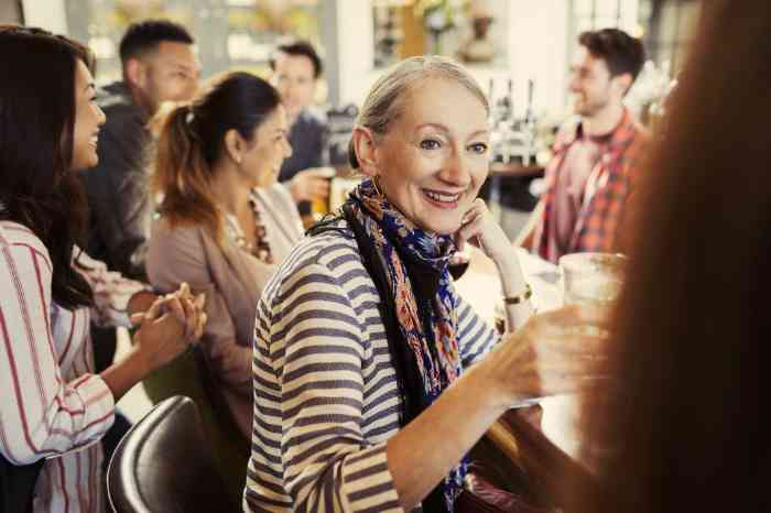 A woman enjoying a drink in a bar thanks to her hearing aid background noise management