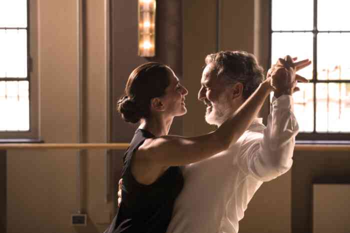 an elderly man and a woman dancing tango