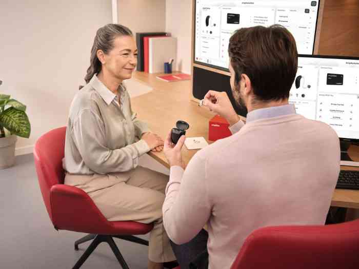 an Amplifon audiologist showing hearing aids to a client