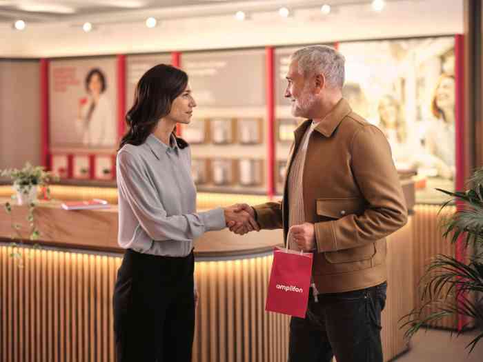 audiologist shaking hands with a man as he leaves an Amplifon clinic with his purchase