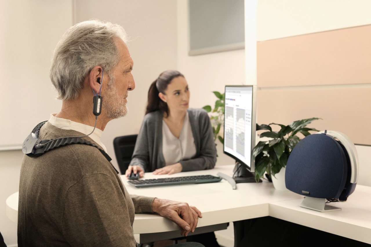 elderly man performing a hearing test with a hearing care specialist
