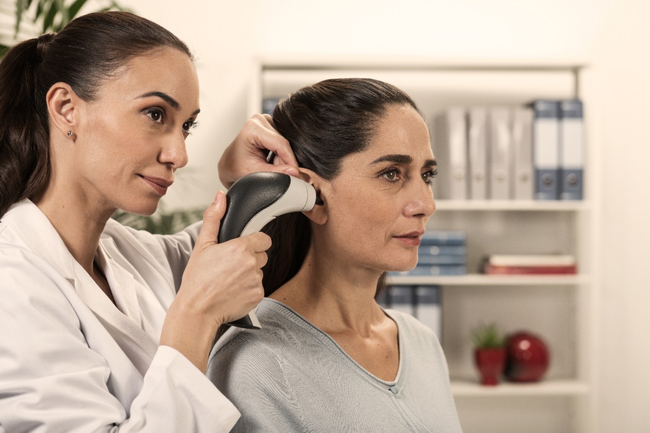 an ENT specialist examining the ear of a boy