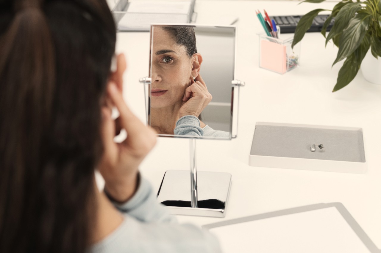a woman looking at herself through a mirror