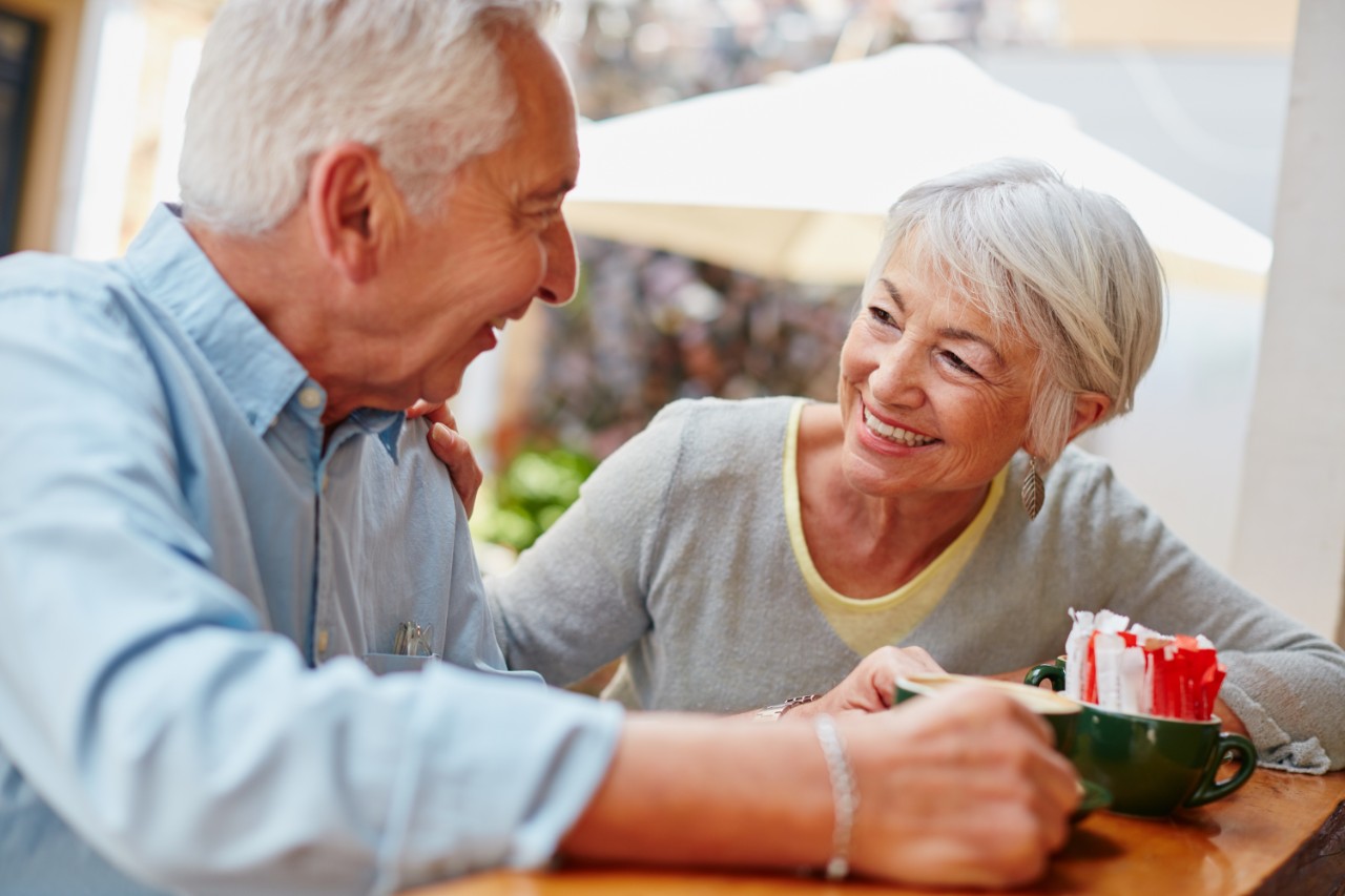 A couple of elderly people talking and smiling at eachother