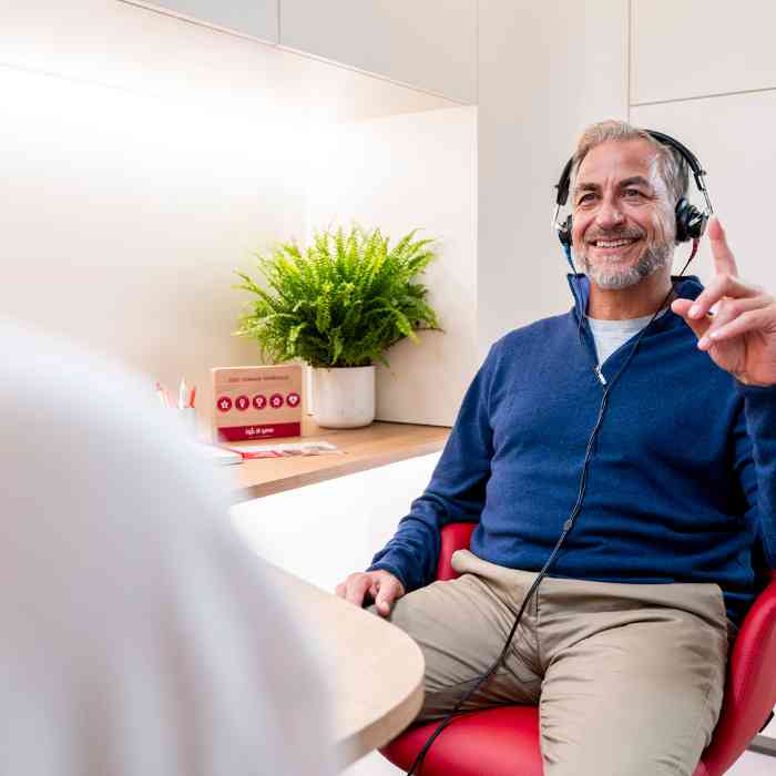 an elderly man doing a hearing test with an audiologist in a national hearing care center