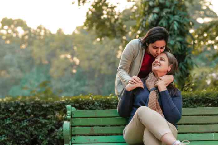 two women hugging sitting on a bench