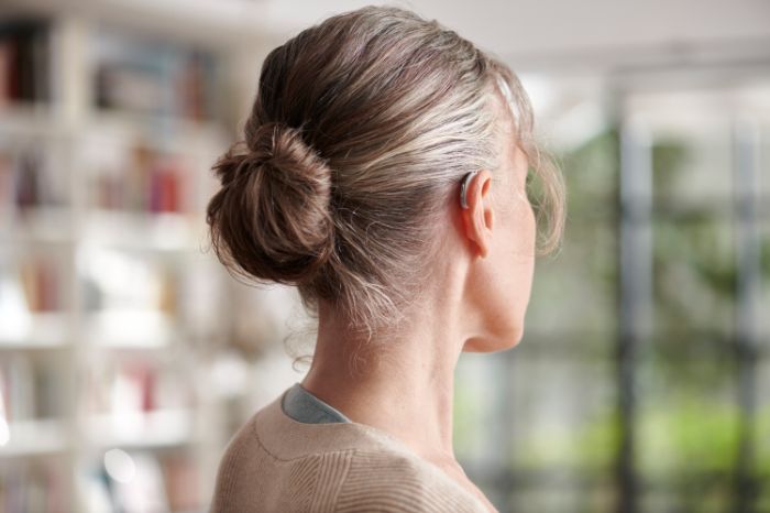 Close-up of a woman wearing a hearing aid from behind