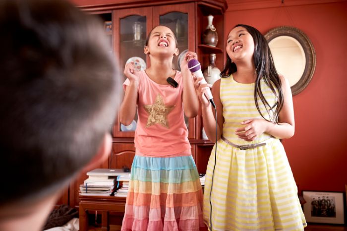 Two female kids singing in front of their father